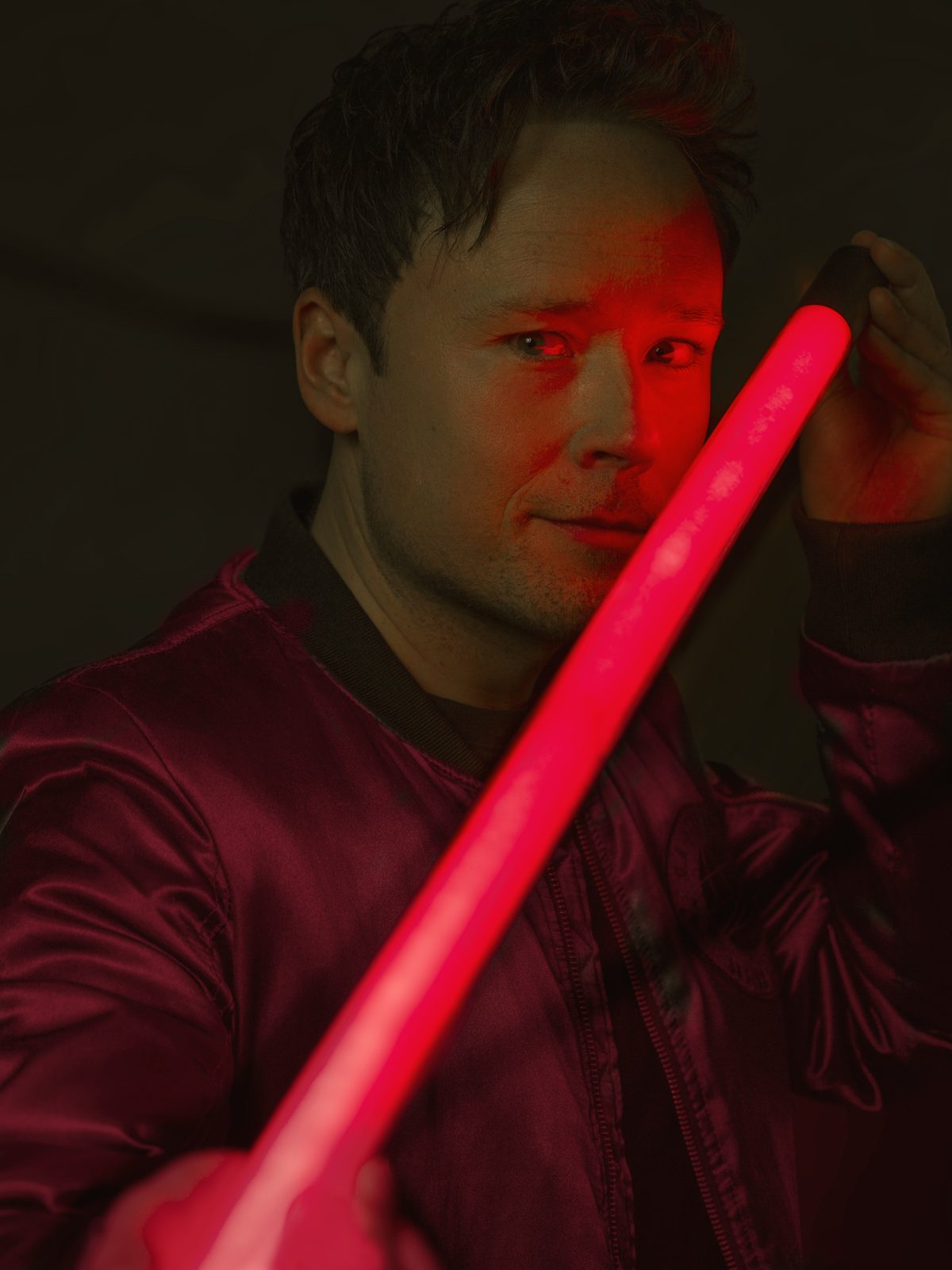 Daniel Kane med röd neonstav Daniel Kane, magiker och trollkarl, med en röd neonstav i rött ljus